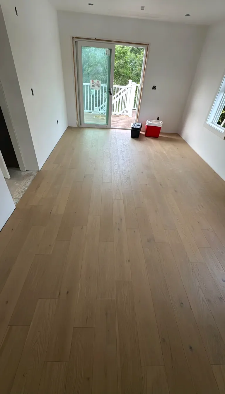 Bright room with a finished white oak hardwood floor and large windows